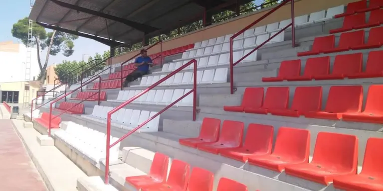 Milloren el camp de futbol amb baranes a les grades i actuacions al camp