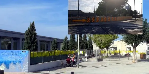 Pinten i col•loquen llaços grocs a la façana de l’Escola La Portalada i a l’Avinguda Marquès de Tamarit