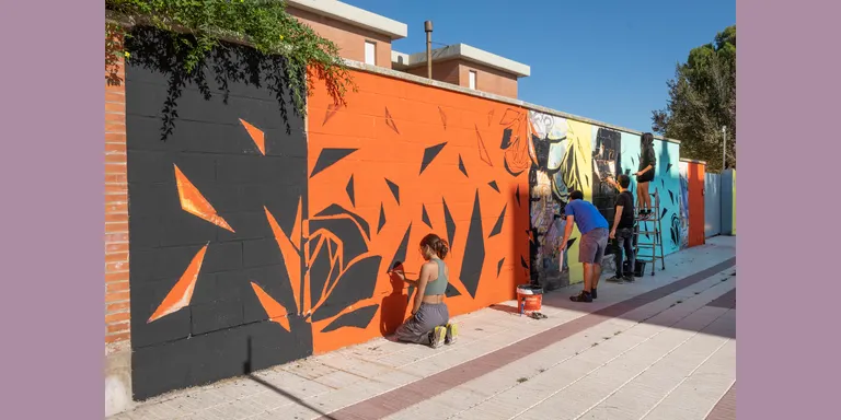 Alumnes de l’Escola d’Art pinten un mural al carrer Vidal i Barraquer a tocar de les escoles