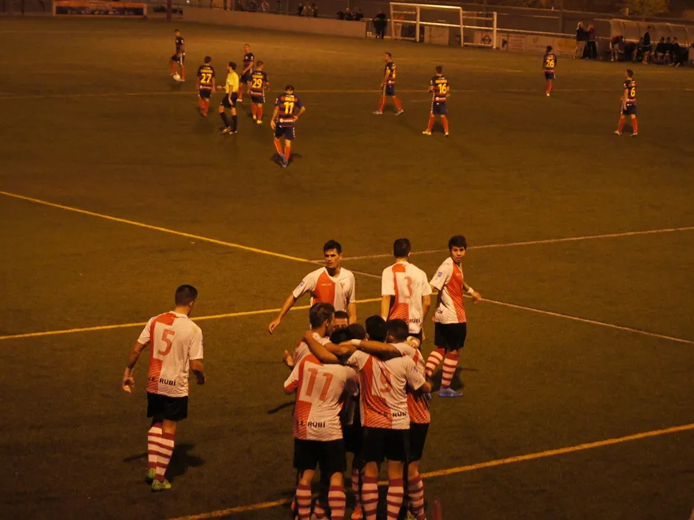 L'alegria dels rubinencs després del gol amb el contrast dels rivals al centre del camp