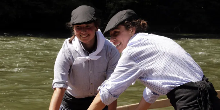Quatre rais rememoren el transport fluvial de la fusta a la Pobla de Segur amb dues dones damunt les embarcacions