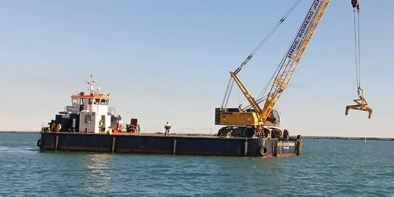 Arriba al port d'Arenys l'embarcació que treballarà en la reconstrucció de l'espigó de Sant Pol de Mar