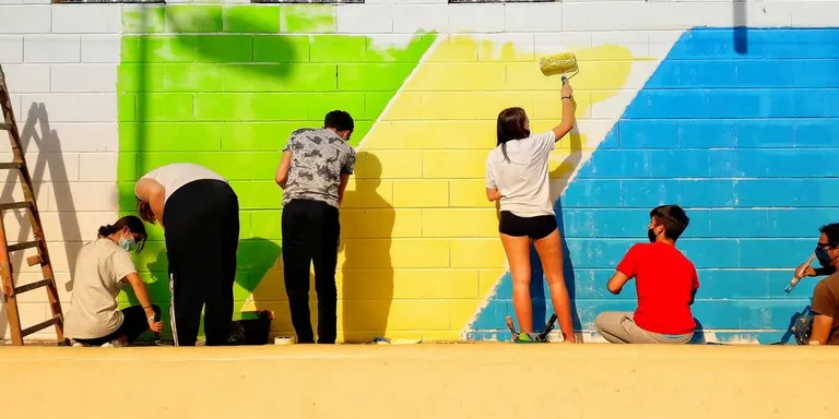 Alumnes de l’Institut Pere Ribot estan pintant un mural a l’Escola Pérez Sala