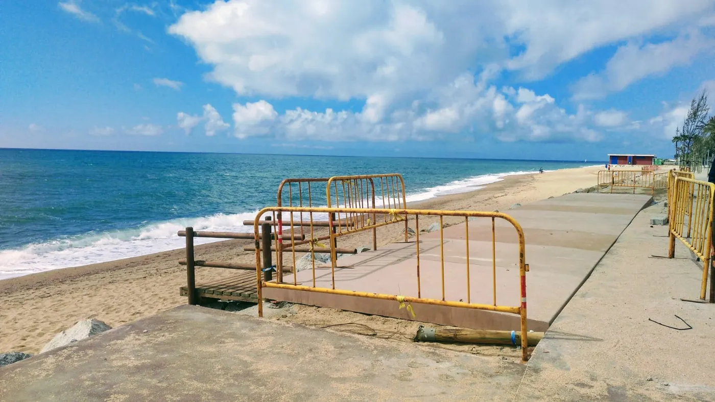 Els operaris instal.len les peces de formigó del carril bici a la Platja dels Pescadors