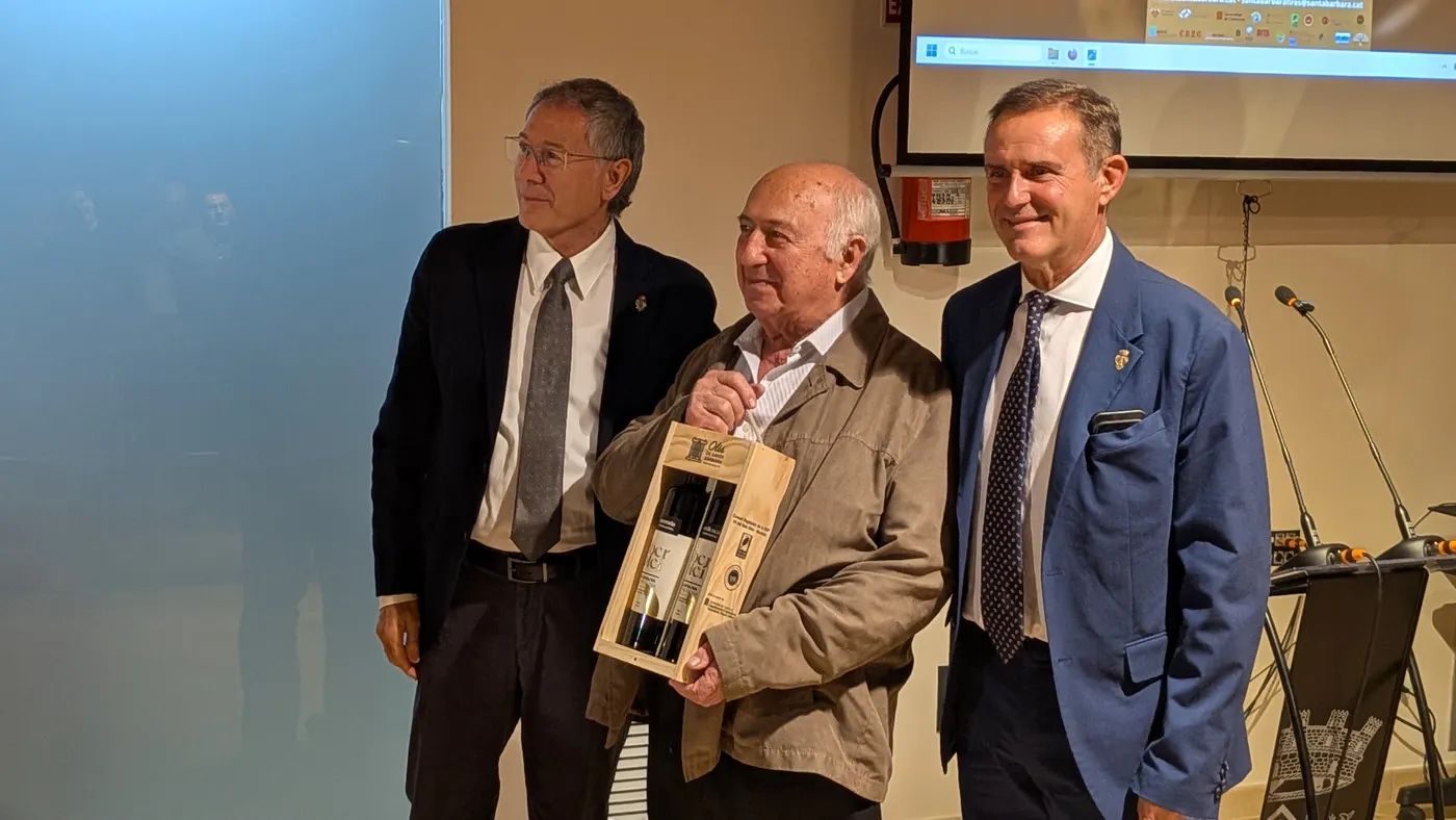 El padró de les XXIX Jornades Gastronòmiques de la Cuina de l’Oli, XXIX Jornades Gastronòmiques de la Cuina de l’Oli i del cartell de la trentena Fira de l’Oli de la Mediterrània. Fernando Valls Simó, rebent un detall durant la presentació.