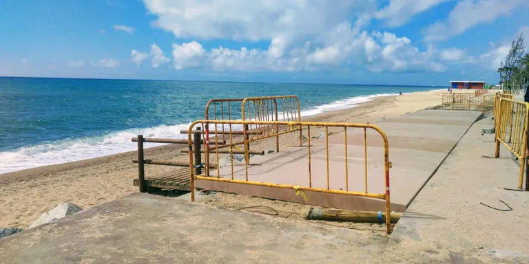 Els operaris instal.len les peces de formigó del carril bici a la Platja dels Pescadors