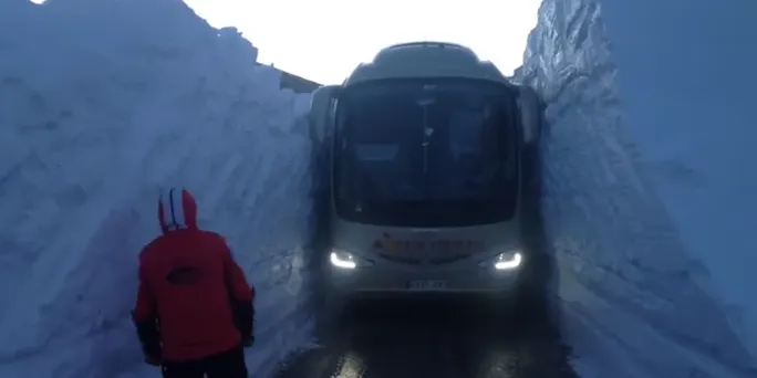 Un autocar supera el coll de la Creueta entre dos murs de neu