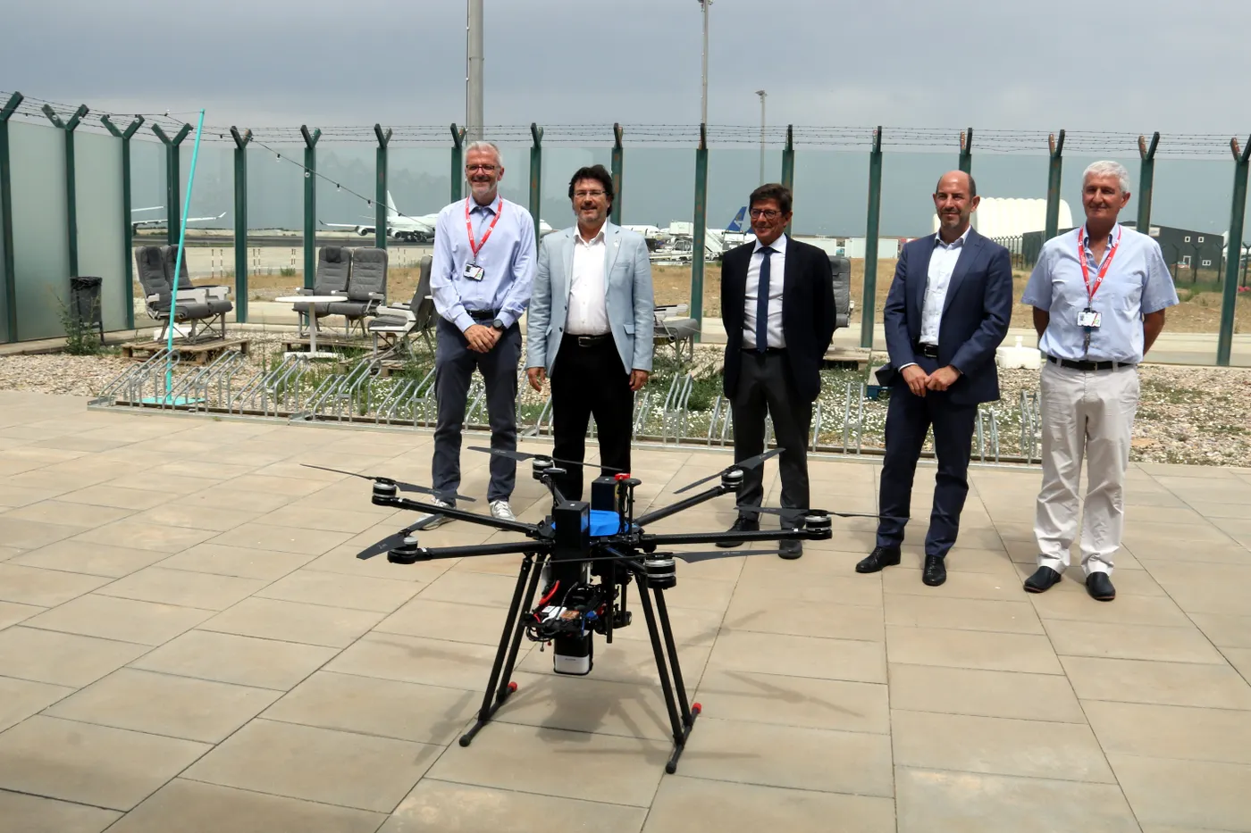 Els responsables d'Aeroports de Catalunya, Isidre Gavín i Jordi Candela, amb el director de l'Aeroport de Lleida-Alguaire, Antoni Serra, i un representant d'Applus+, darrera d'un dron a les instal·lacions de l'aeroport lleidatà.