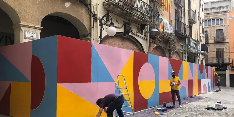 Dos artistes vallencs pinten un mural a la plaça de l’Oli