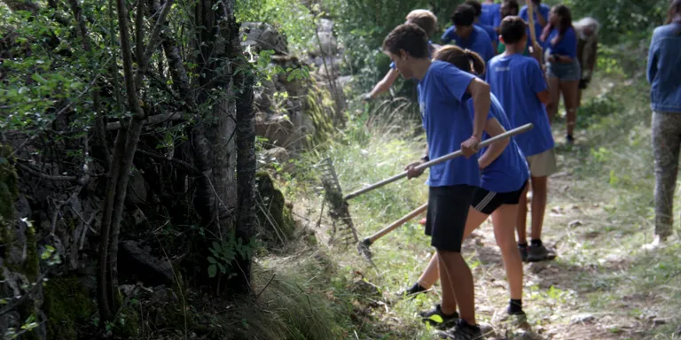 Una vintena de joves condicionen camins i murs del poble de Pi en el marc d'un camp de treball