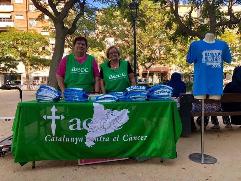 Tiquets i samarretes per la marxa de l'AECC a la venda a la plaça Mèlies i al Centre Cívic Poblenou
