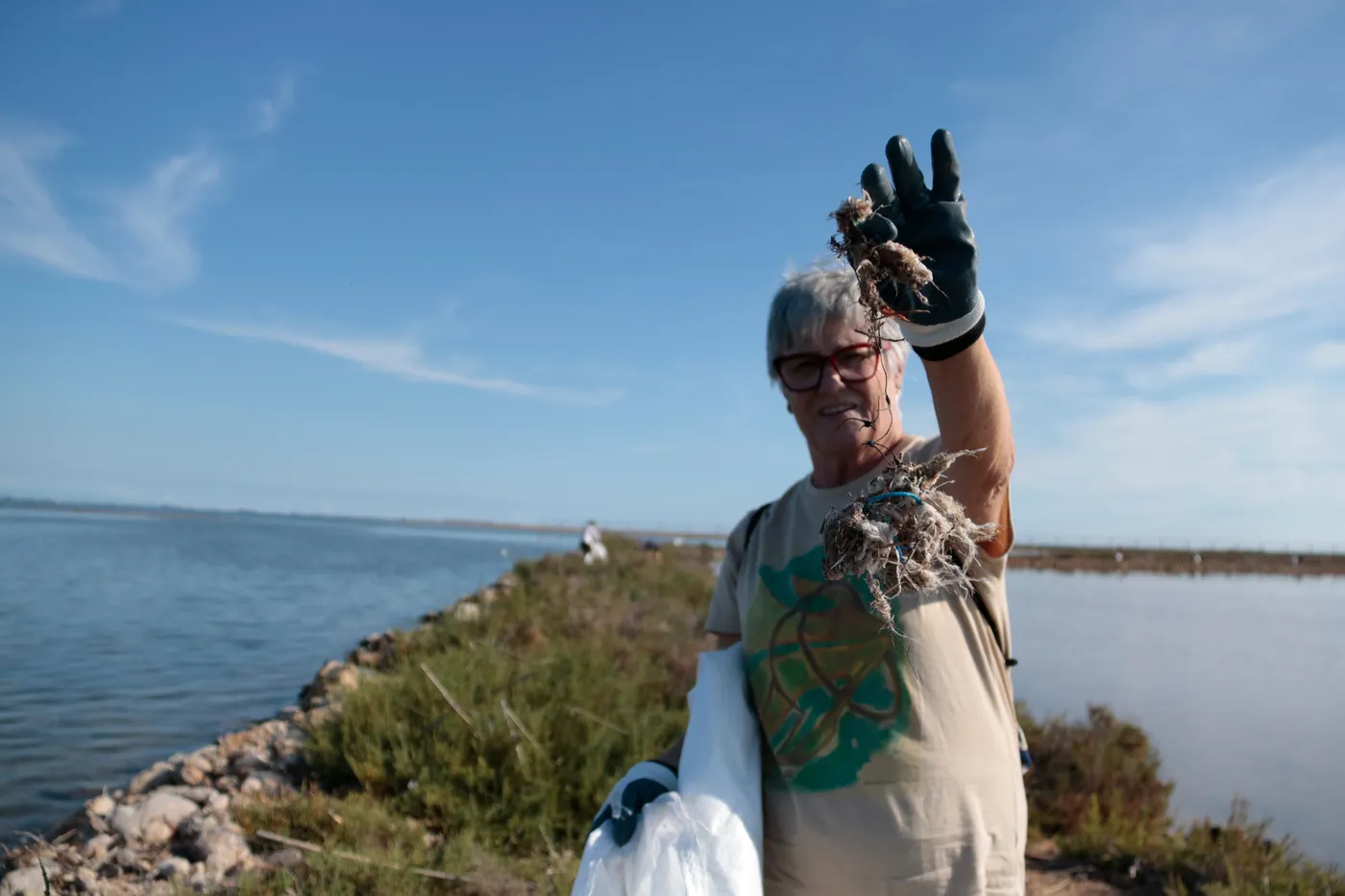 La voluntària Isabel Vendrell mostra residus provinents del mar que ha retirat a les Salines de la Trinitat