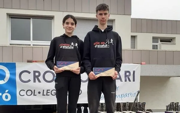 Els atletes Miguel Serra i Emma Vendrell reben els trofeus de campions de la Lliga Comarcal de Cros del CET