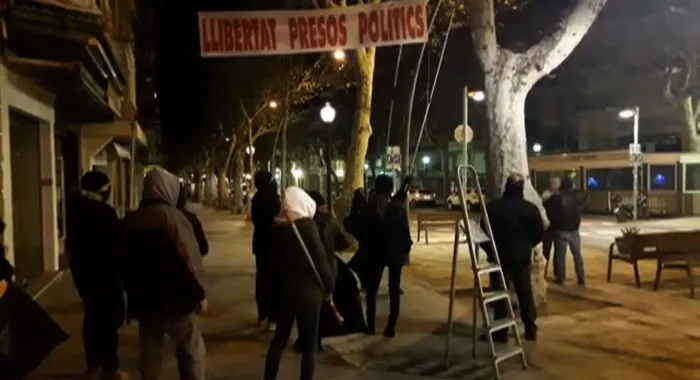 Un grup d'encaputxats treu les estelades i pancartes de la riera