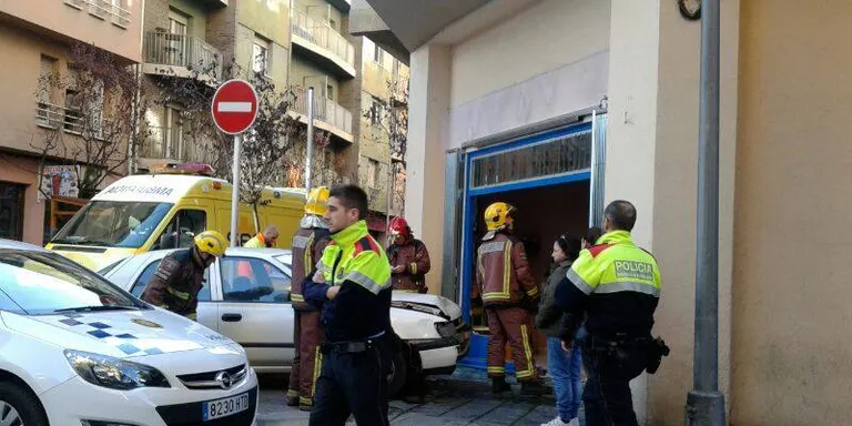 Un cotxe s'encasta contra un aparador al carrer Llorenç Tomàs i Costa