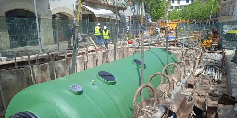 Una grua de grans dimensions col·loca el dipòsit separador d’hidrocarburs a la Rambla Jaume I